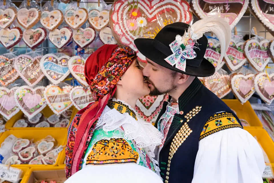 Krojovaný pár se líbá mezi perníkovými srdci
