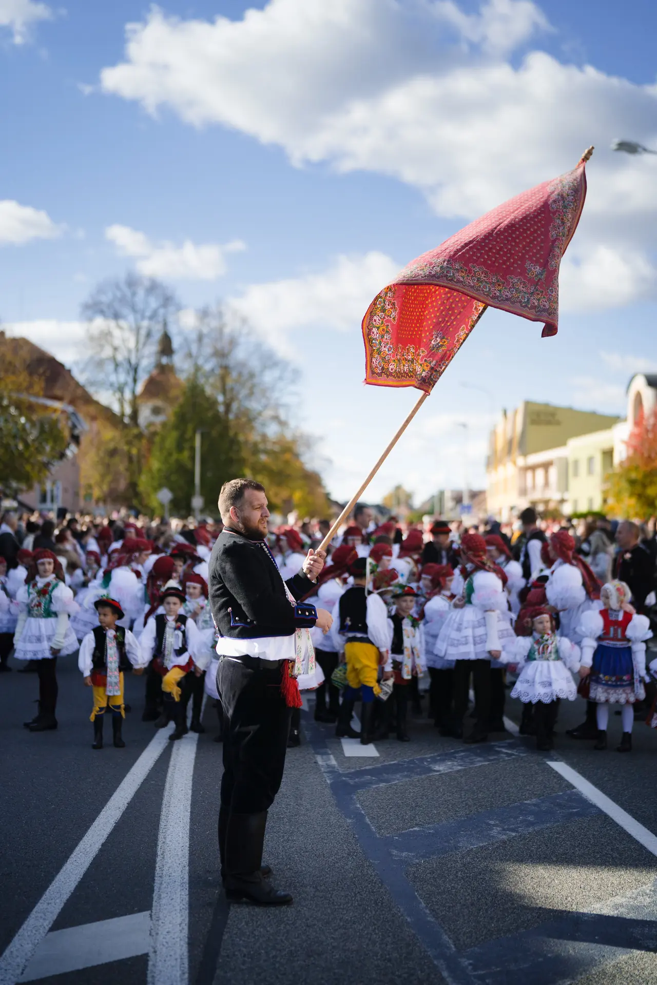 Mládenec s hodovým praporem uprostřed průvodu
