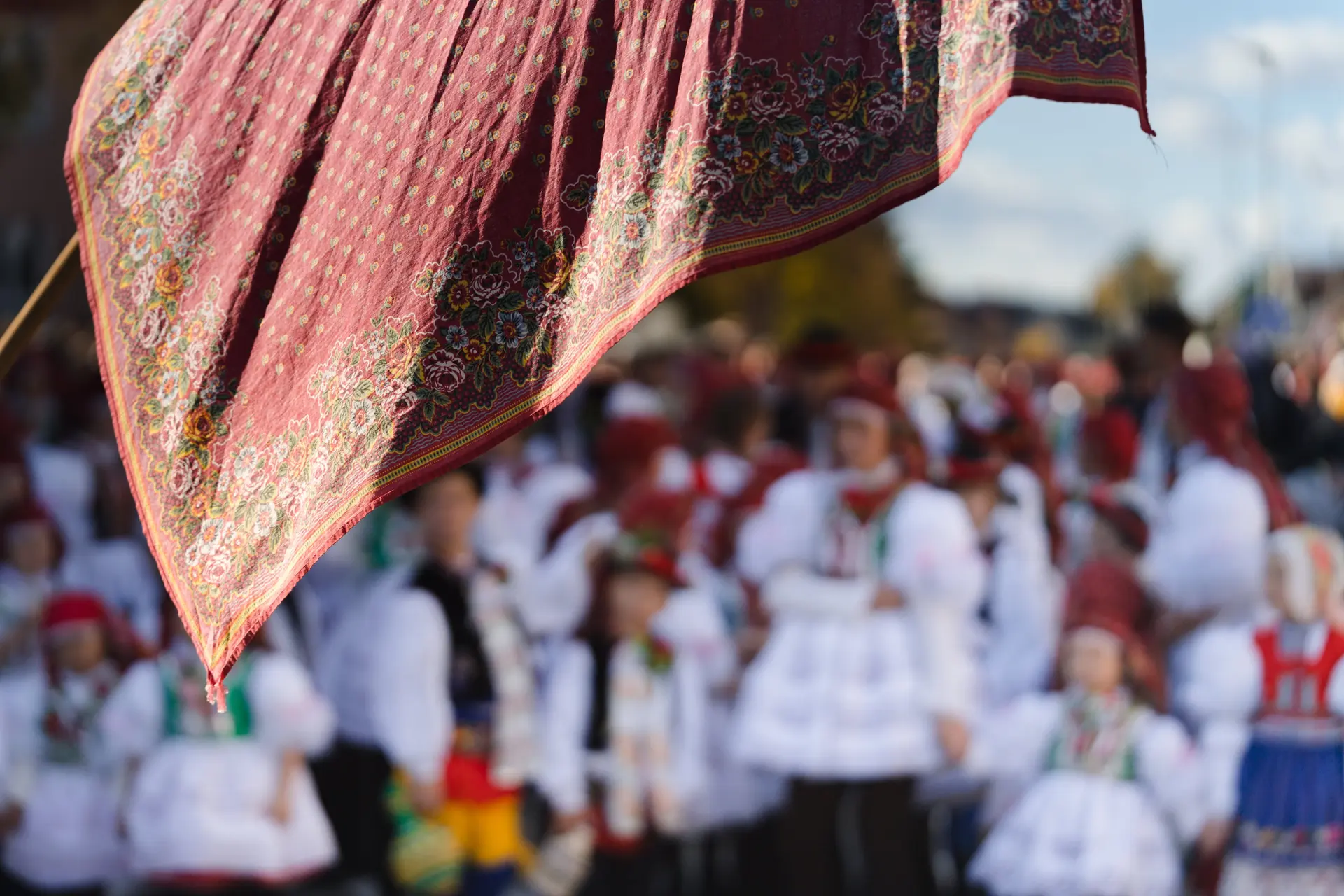 Vyšívaný šátek na praporu nad průvodem