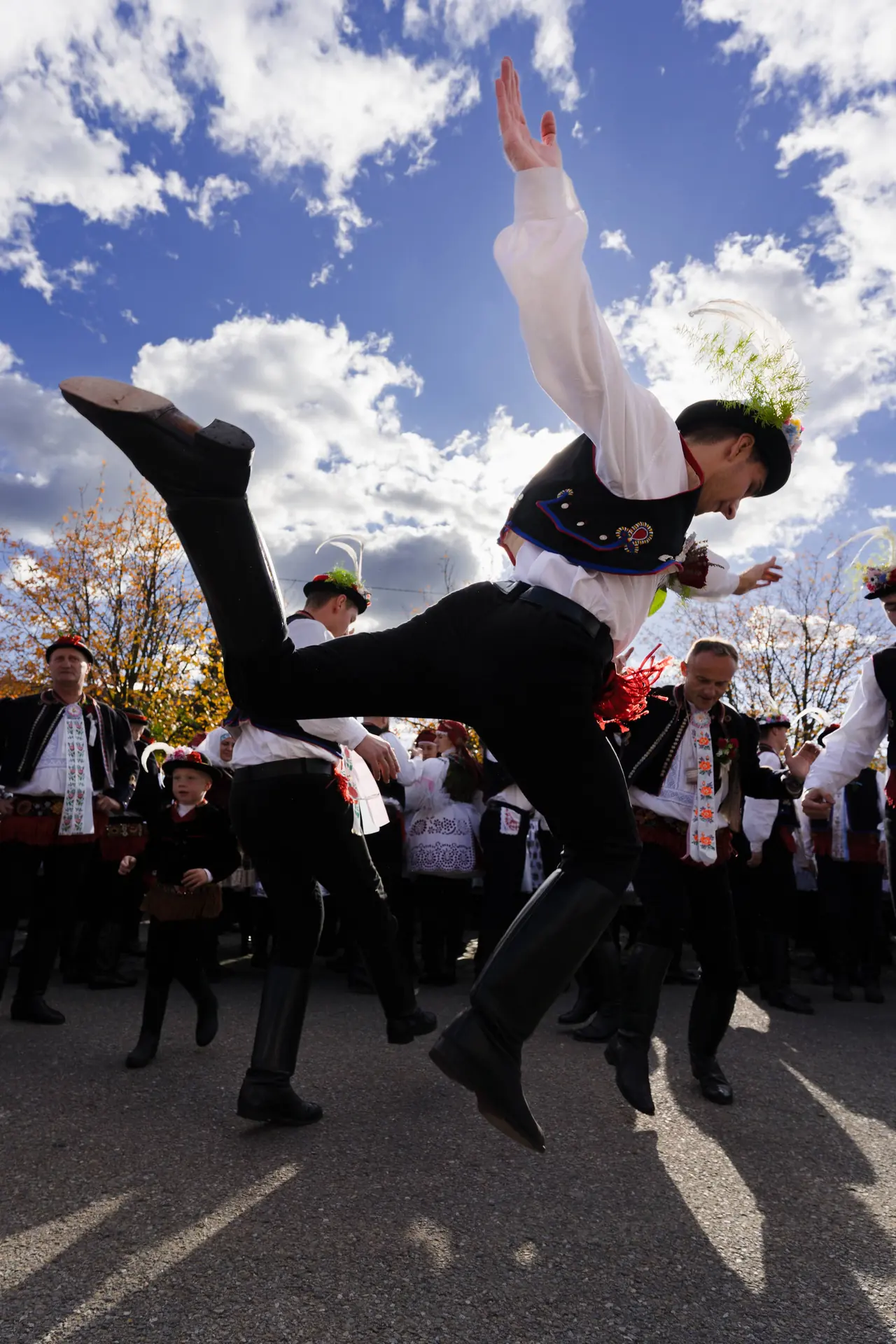 Tanečník ve výskoku nad hlavami průvodu